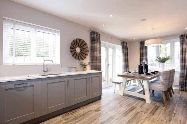 A modern and cozy kitchen with gray cabinets, a wooden dining table