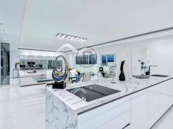 A modern, sleek kitchen and living space with a mi