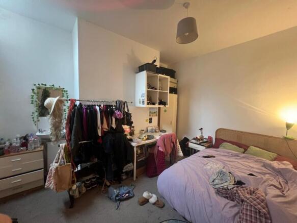 Cozy furnished bedroom with shelving and natura...