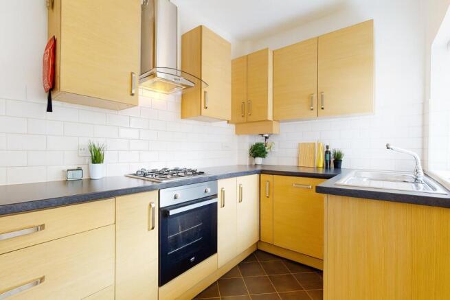 Bright, modern kitchen with light wood cabinetr...