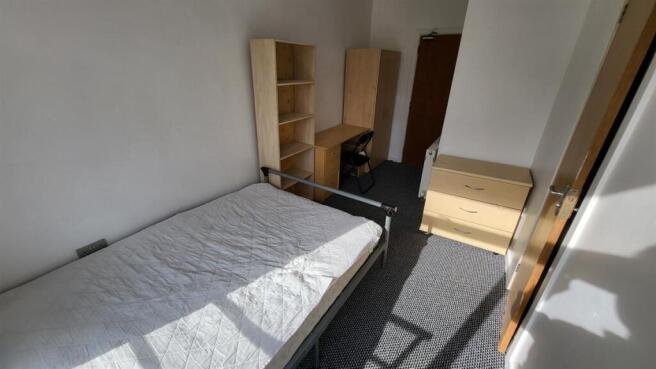 Bright, simply furnished bedroom with a single ...