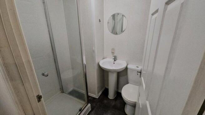 A neat and functional bathroom featuring a walk...