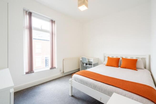Bright and welcoming double bedroom featuring a...