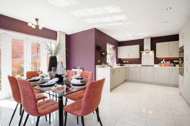 A glass-top dining table with coral chairs sits in the foreground