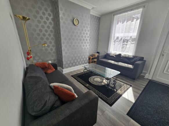 A spacious and well-lit living room featuring c...