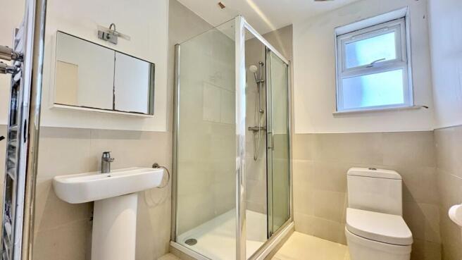 Bright, modern bathroom with glass shower cubic...