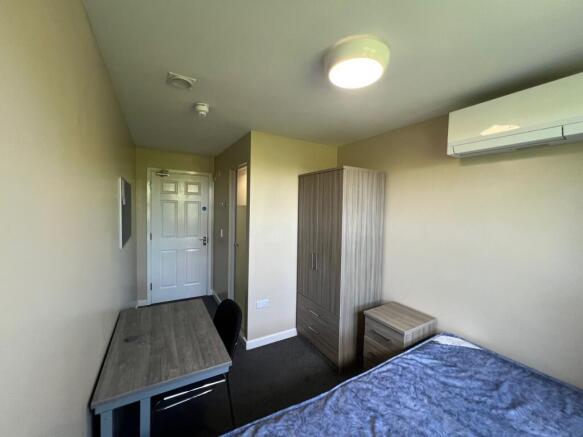 Well-appointed single bedroom with a study desk...