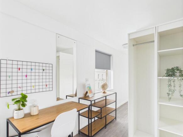 Bright, modern bedroom with a neat study area, ...