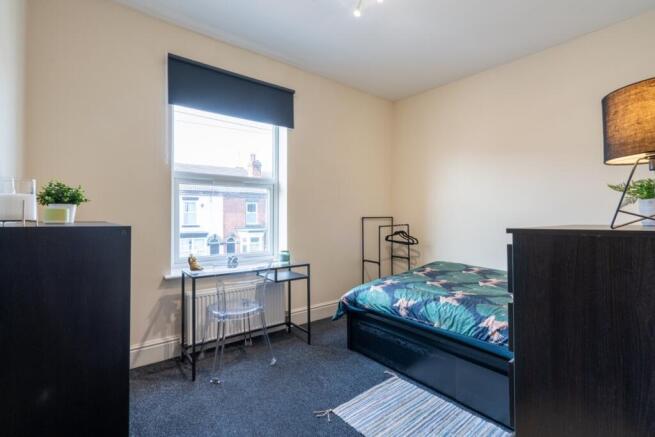 Bright, neatly presented bedroom featuring a do...