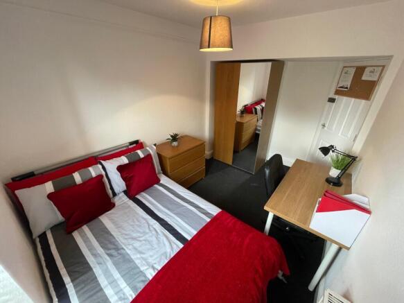 Bright, well-furnished bedroom with a neatly ma...