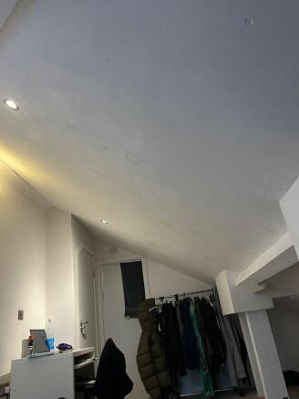 Cozy attic bedroom with a sloped ceiling, reces...