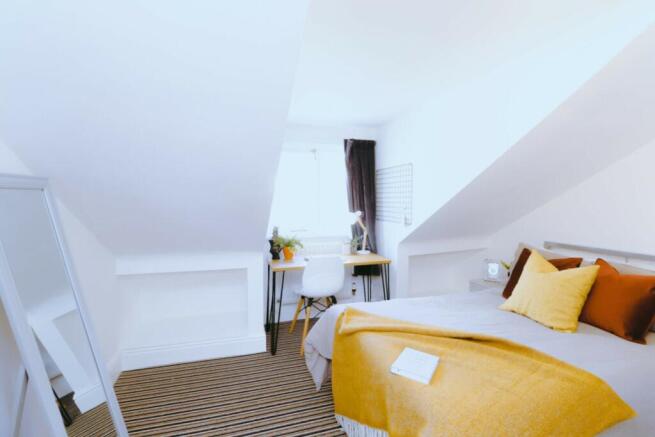 A bright and inviting double bedroom featuring ...