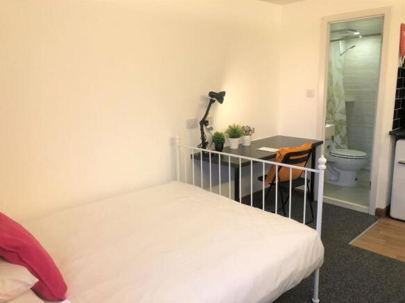 A cozy and well-kept single bedroom featuring a...