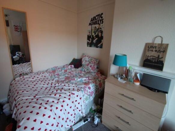 A cozy bedroom with a double bed covered in a p...