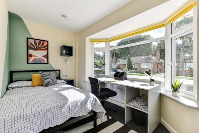Bright bedroom with large bay window study area...