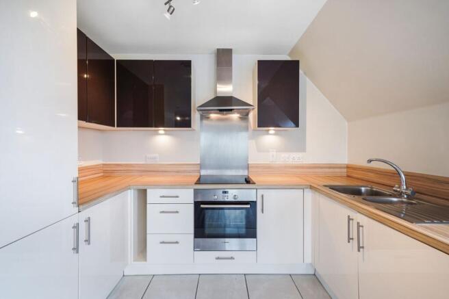 Modern kitchen with sleek gloss units and wood ...