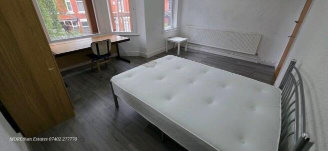 Bright double bedroom with large bay windows, a...