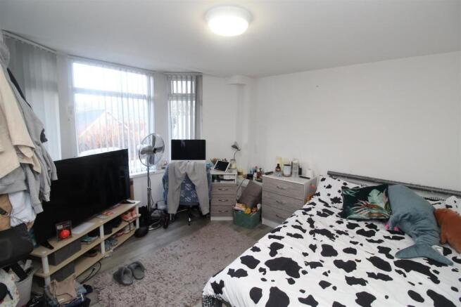 Bright bedroom with large bay window and storag...