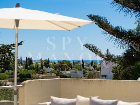 First-floor terrace with parasol offering distant sea views over Carvoeiro Clube, Algarve, from a luxury Moorish villa for sale.