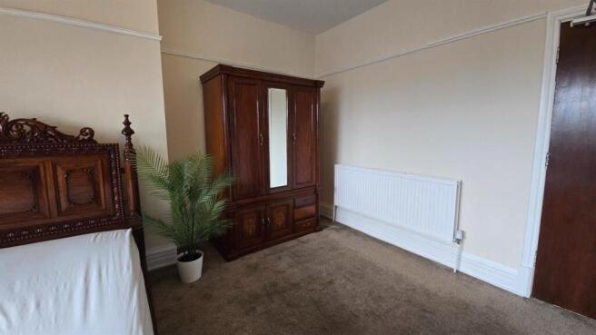 Spacious double bedroom with classic wooden war...
