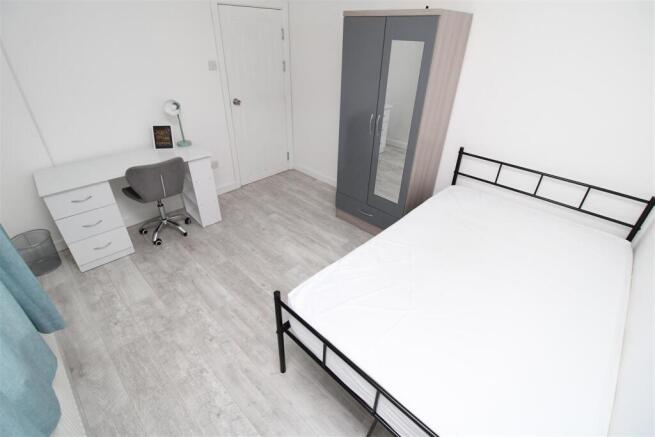 Bright modern bedroom with desk and wardrobe...