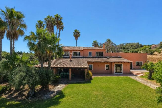 Large house with lawn and palm trees