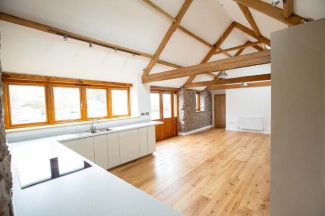 Bright open-plan living space with exposed timb...