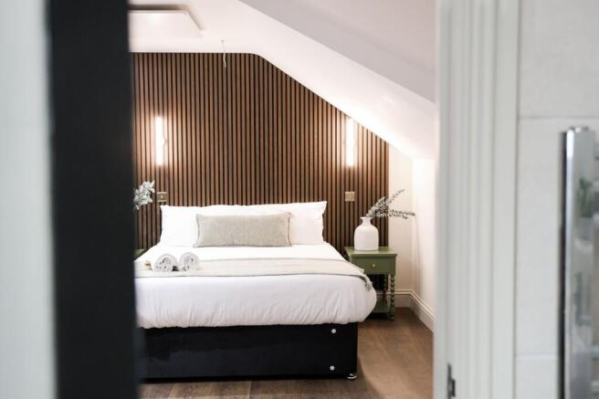 Stylish double bedroom with feature wood wall...