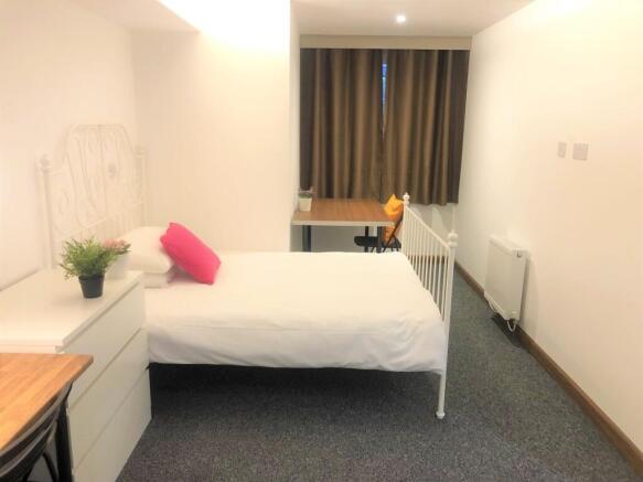 A bright and tidy single bedroom featuring a wh...