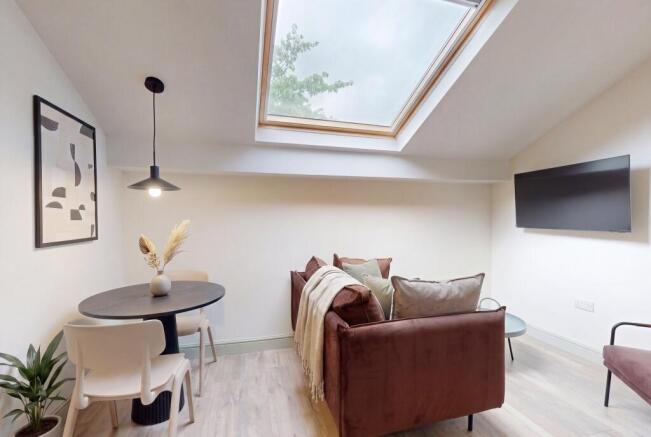 Bright lounge with skylight and chic dining are...