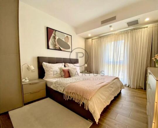 A cozy bedroom with a double bed, accent pillows, 