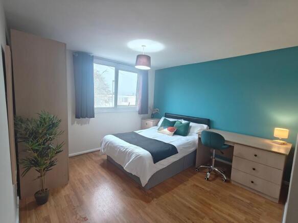 Bright, stylish bedroom with desk and storage...