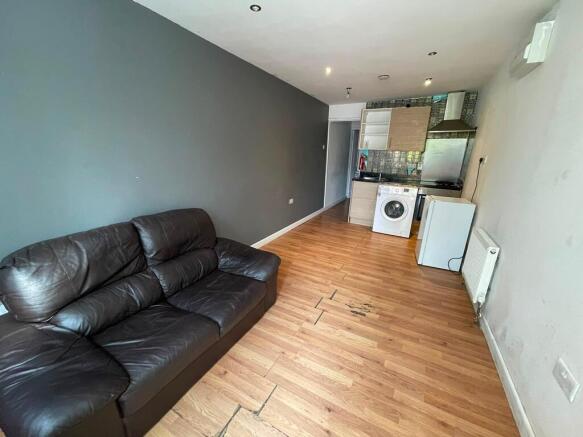 Open-plan living space with a sofa and kitchen...