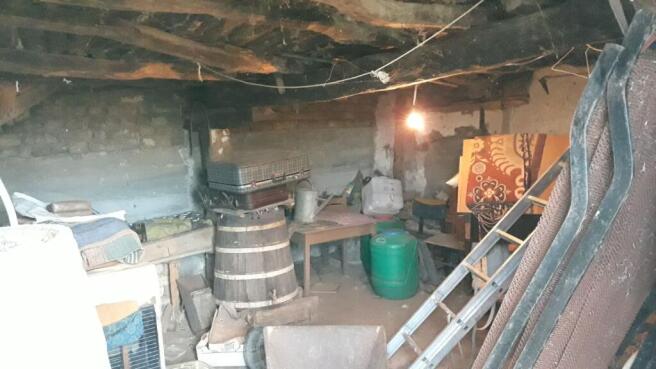 Basement area of the house featuring exposed beams and stored household items