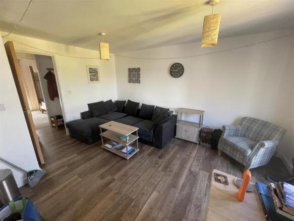 Inviting lounge with large sofa and wood floors...