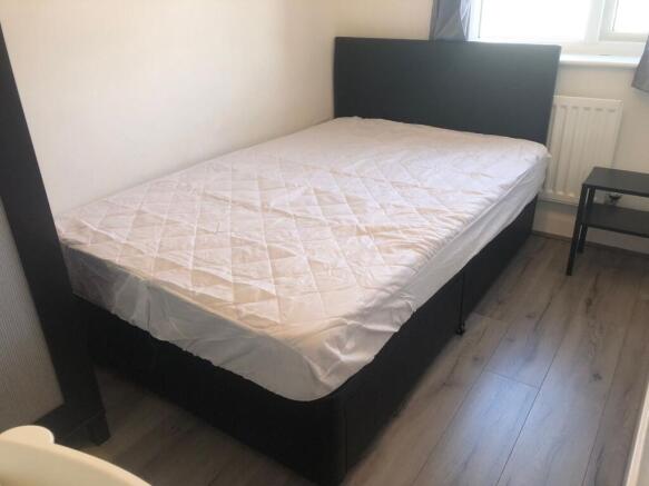 Bright, simply furnished bedroom with a comfort...