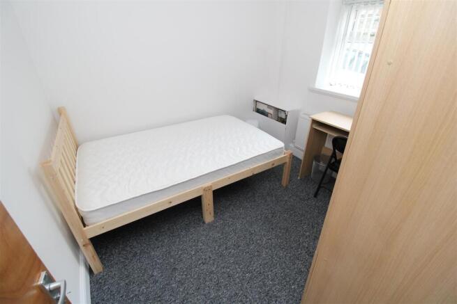 Bright bedroom with desk and modern wood frame...