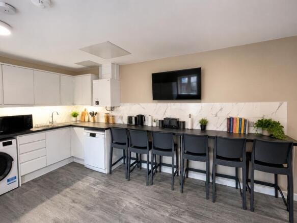 Modern kitchen with a sleek breakfast bar and T...