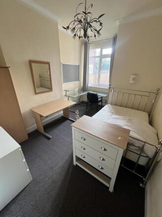 Bright bedroom with ample desk space and storag...