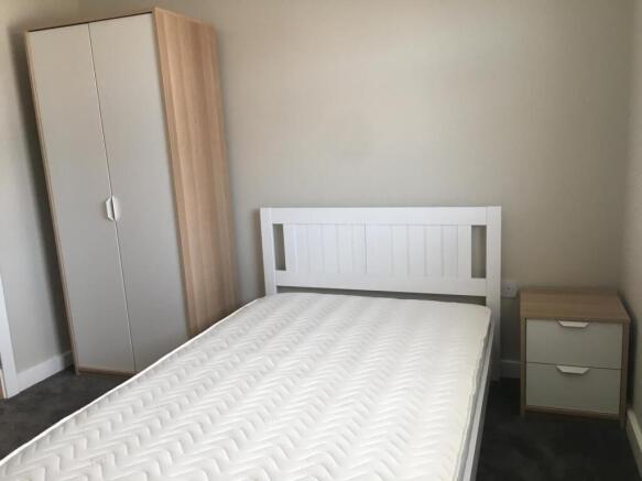 Bright, simply furnished double bedroom with a ...