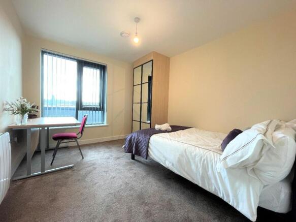 A bright and tidy single bedroom featuring a co...