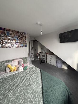 Comfortable bedroom featuring a large bed, cozy...