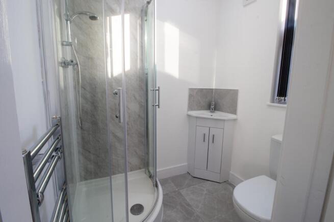A clean and well-lit bathroom featuring a showe...