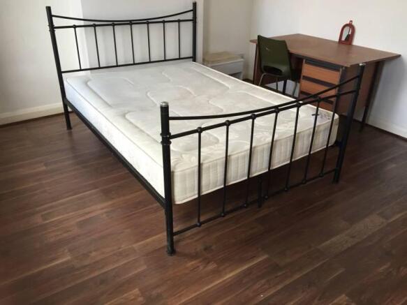 Bright bedroom with a metal-framed double bed, ...