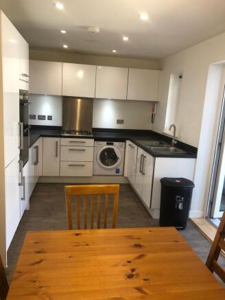 Bright modern kitchen with white high-gloss cab...