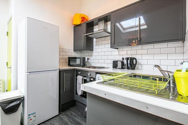 Modern galley kitchen with dark gloss cabinets,...