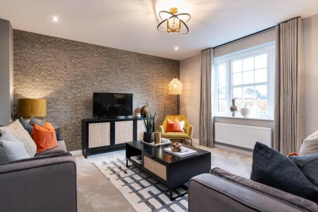 A modern living room with plush grey sofas and a textured accent wall in the foreground
