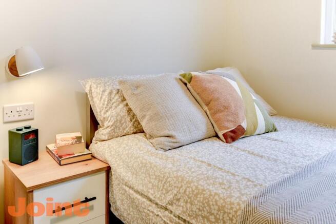 Cosy double bed with stylish bedding and light....