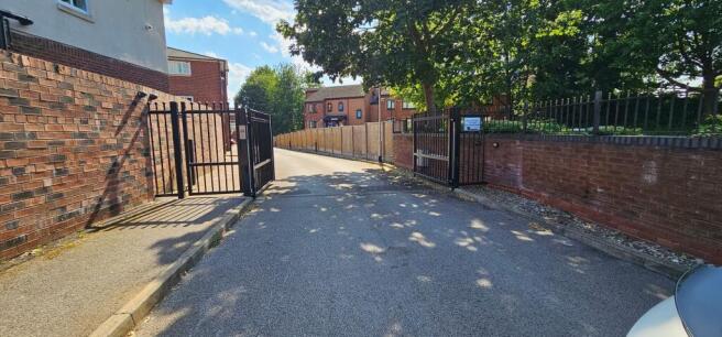 Gated entrance with secure, tree-lined approach...