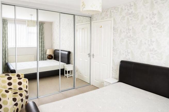 Bright bedroom with large mirrored wardrobes...
